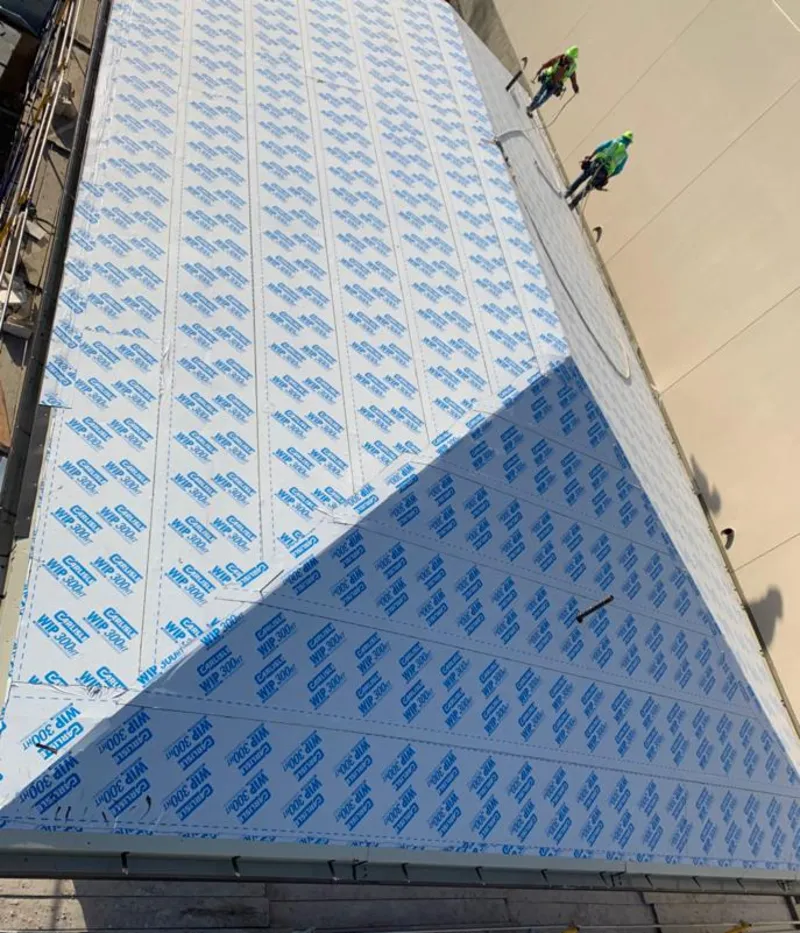 Professional roofers installing underlayment on a metal roof in Mableton